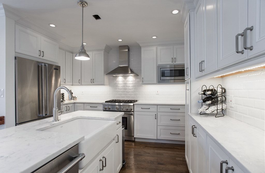 White shaker kitchen with farmhouse sink and quartz counters